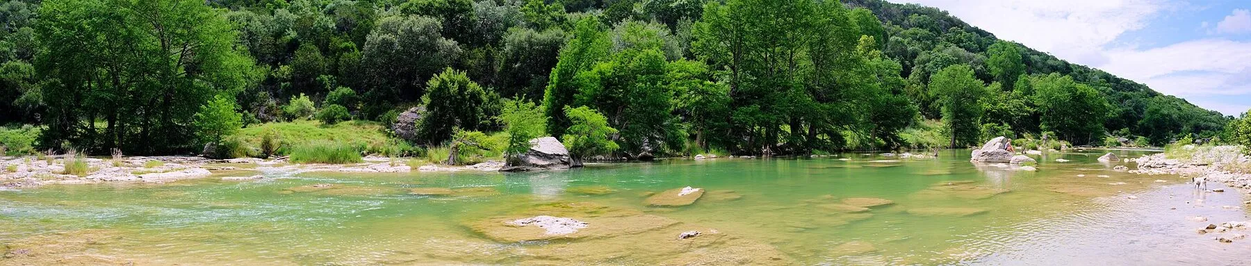 Pedernales River flowing between limestone shelves and cedar-covered banks