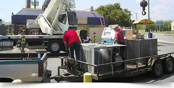 Rosenberg crew beside HVAC units on a trailer with a crane behind them