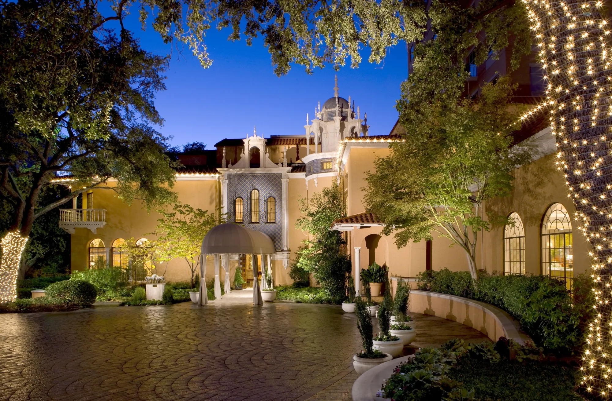 Lit courtyard and entrance at Rosewood Mansion on Turtle Creek at night