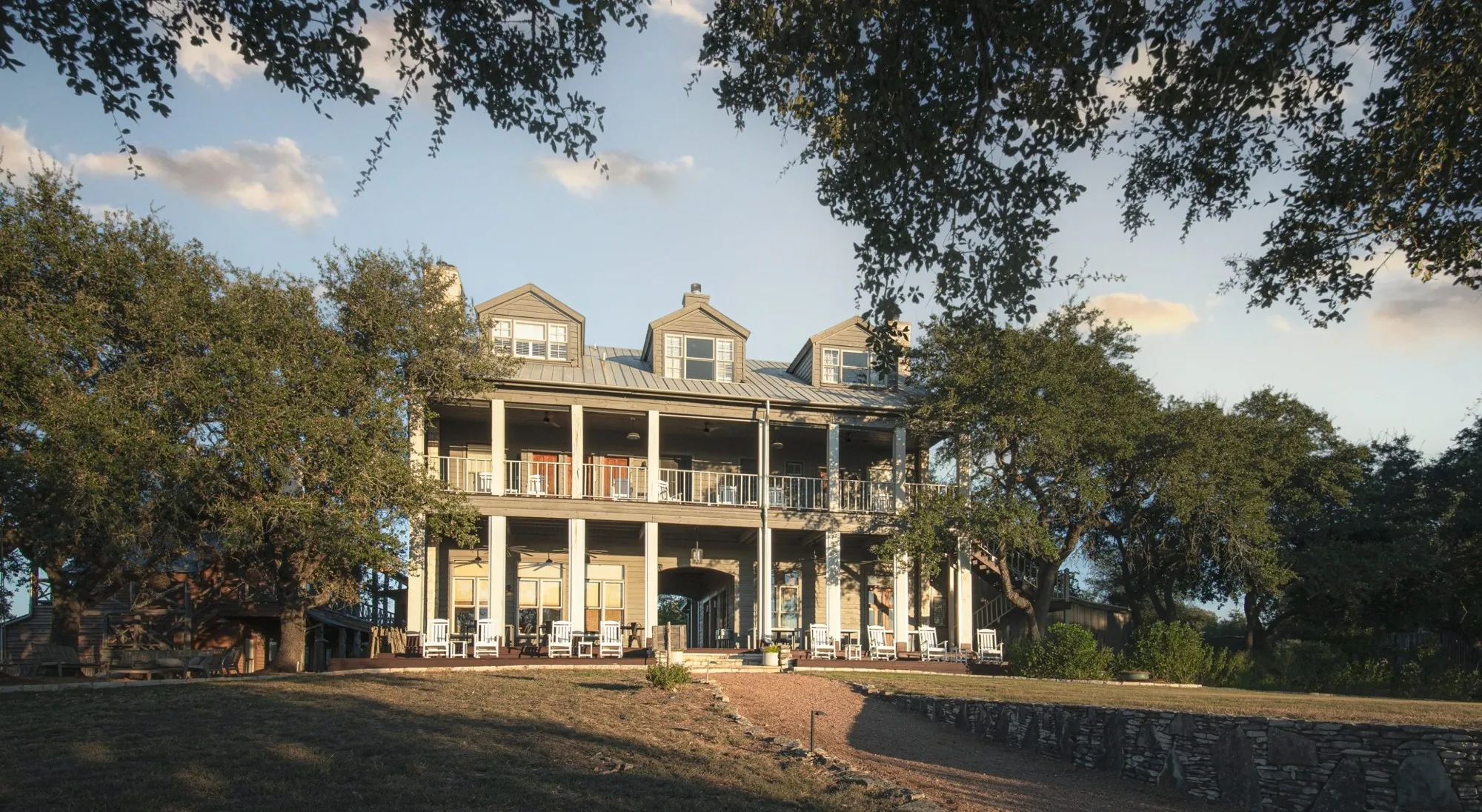 Two-story inn with long white porches at Sage Hill Inn and Spa