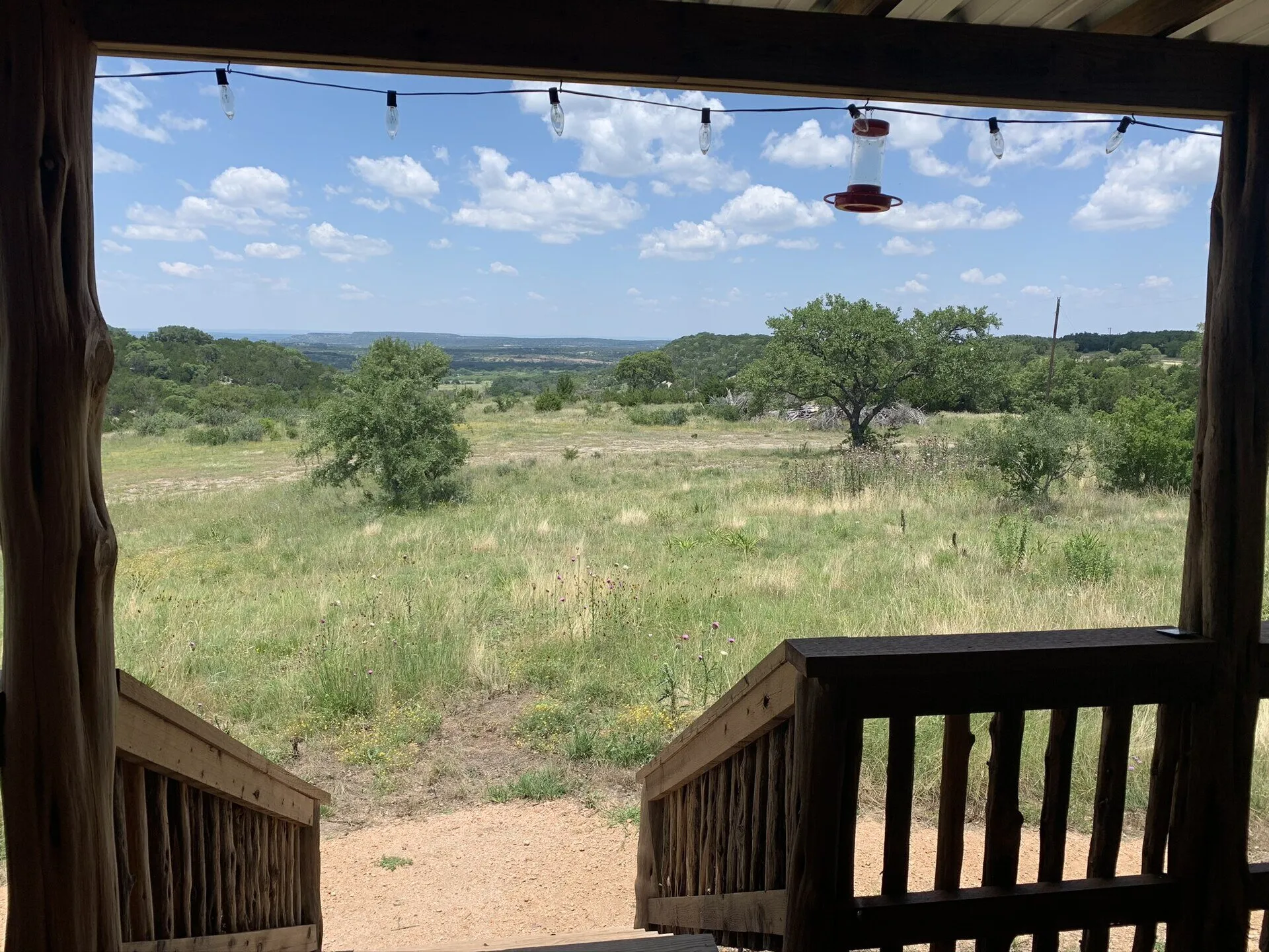 View from a cabin porch across open ranch land north of Fredericksburg