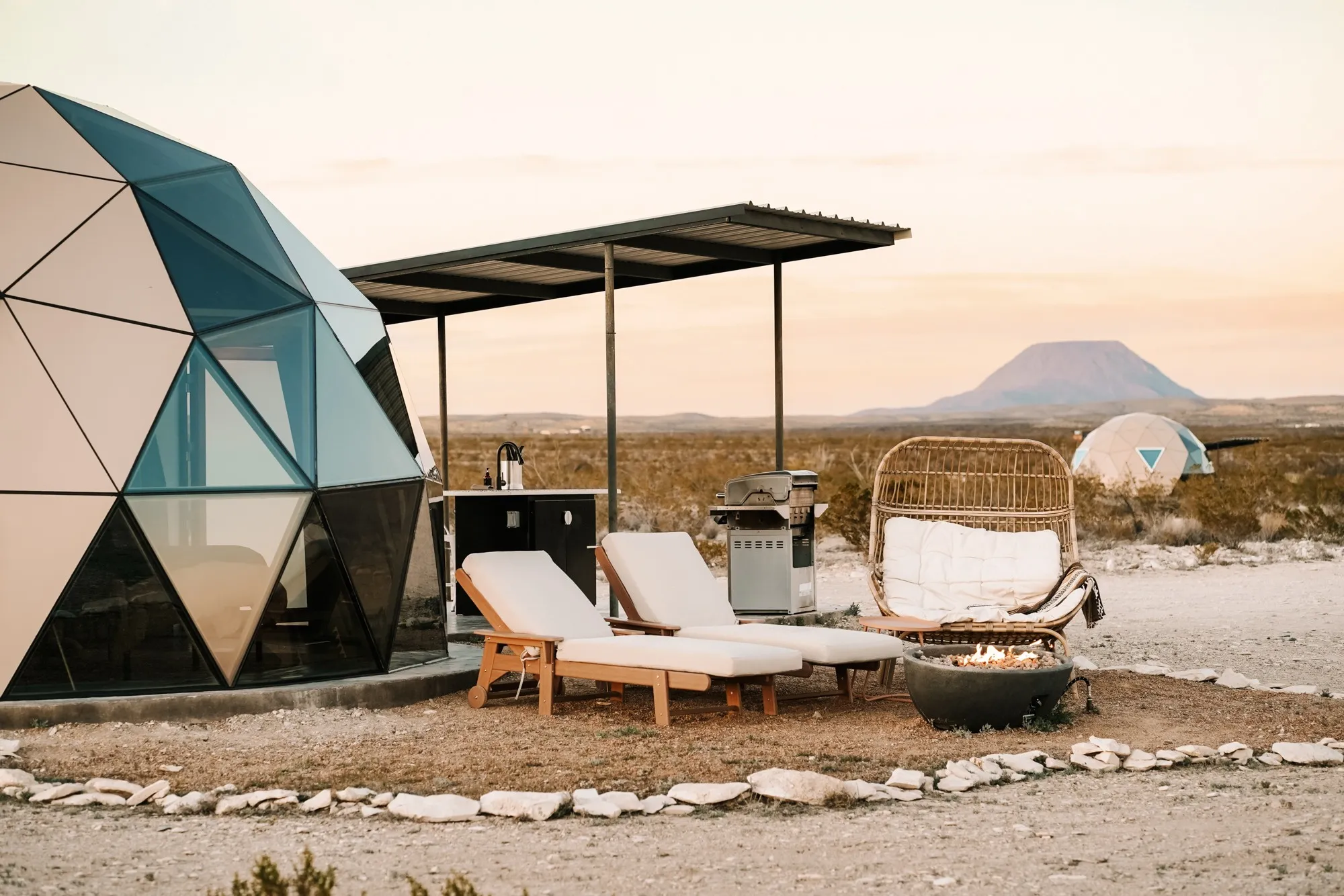 Dome and covered outdoor kitchen facing desert mountains at StarStruck Glamping
