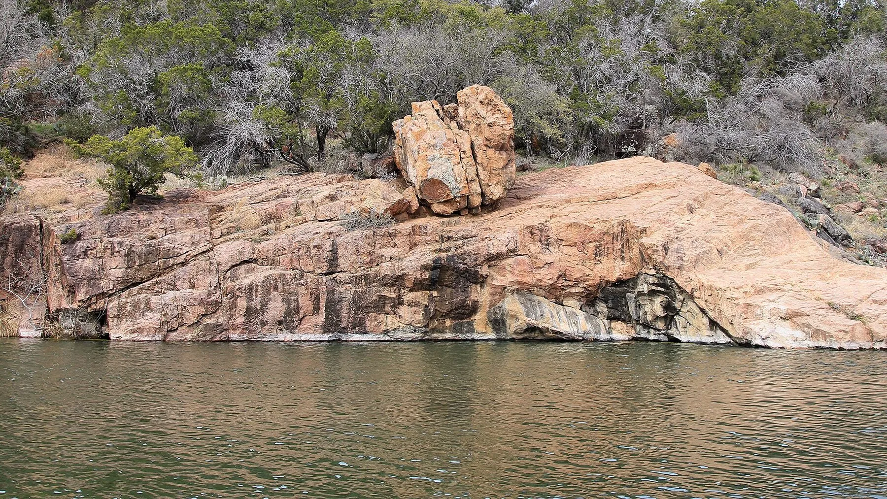 Devils Waterhole at Inks Lake bordered by pink granite and trees