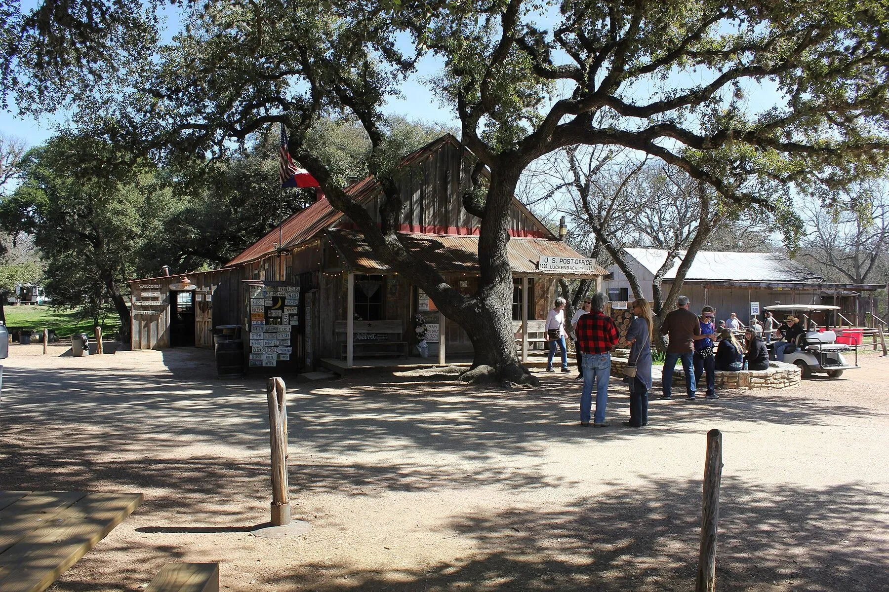 Weathered Luckenbach Post Office and General Store beneath tall trees