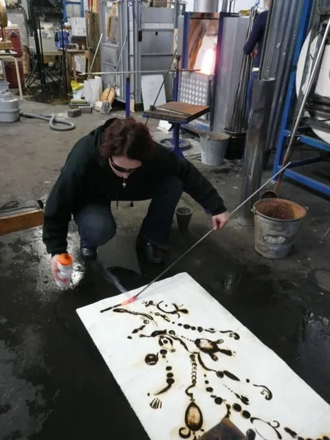 A glass artist works with hot glass in a studio in Zaandam, Netherlands
