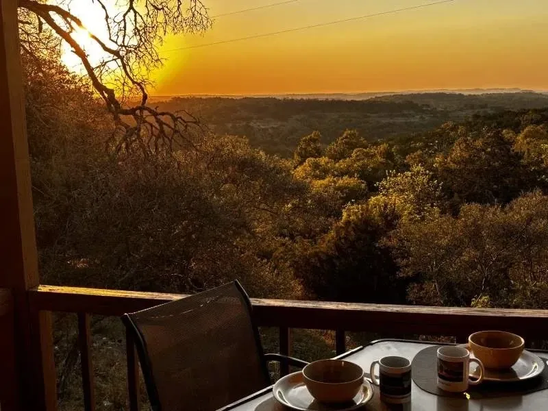 Coffee cups on a cabin deck above the hills at Walnut Canyon Cabins