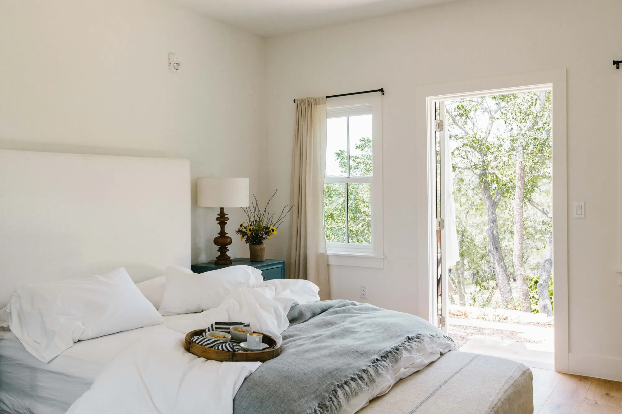 White bed and bright windows in a cottage at The Wayback