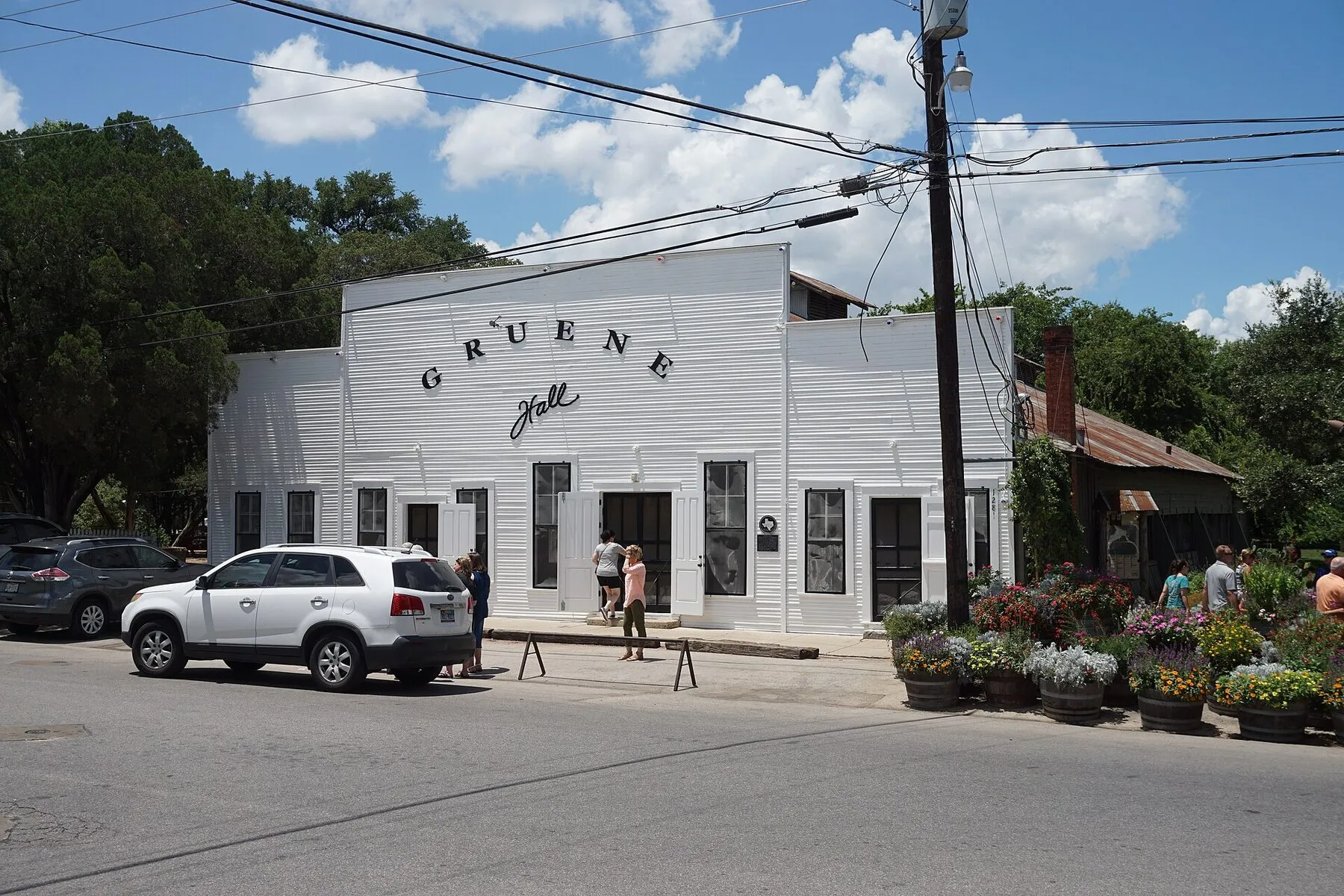 The white wood exterior and neon sign of Gruene Hall in New Braunfels