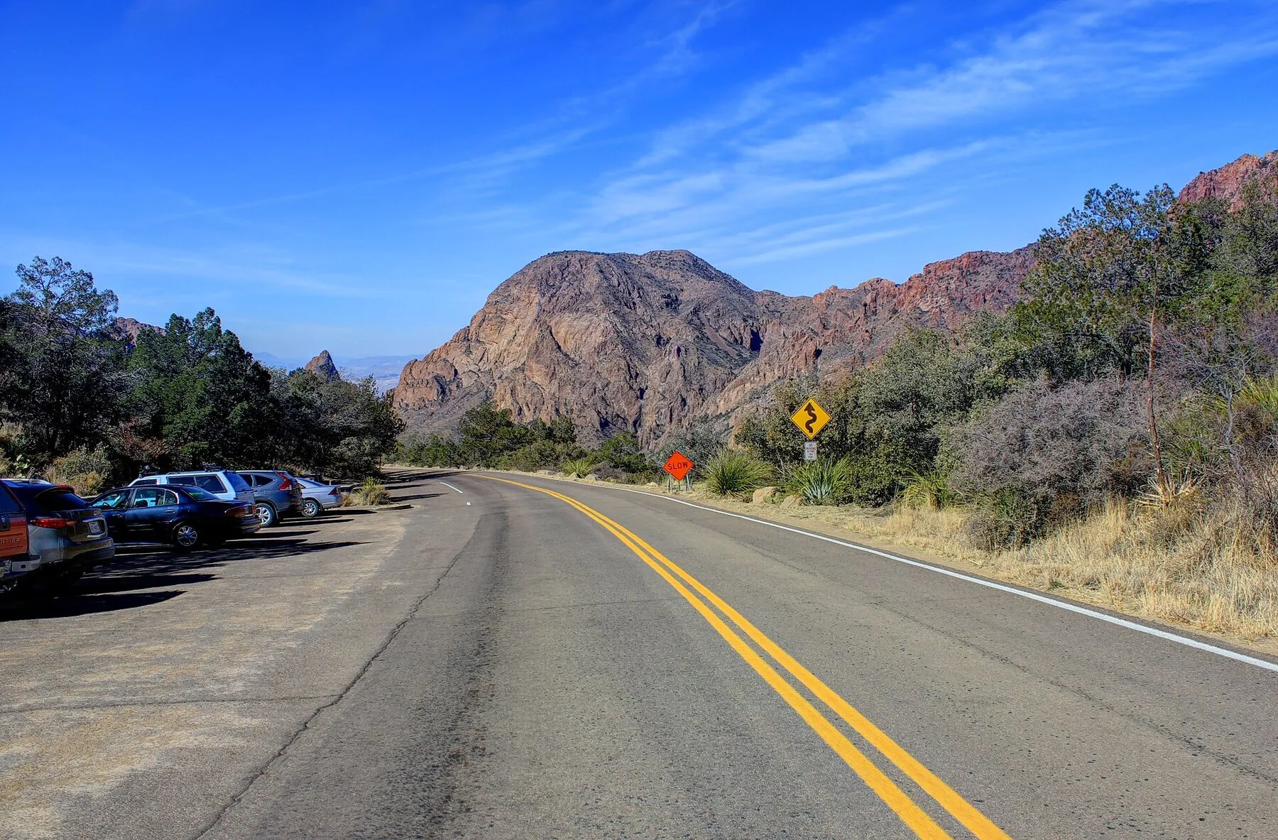 A paved desert road leading toward the Chisos Mountains in Big Bend National Park