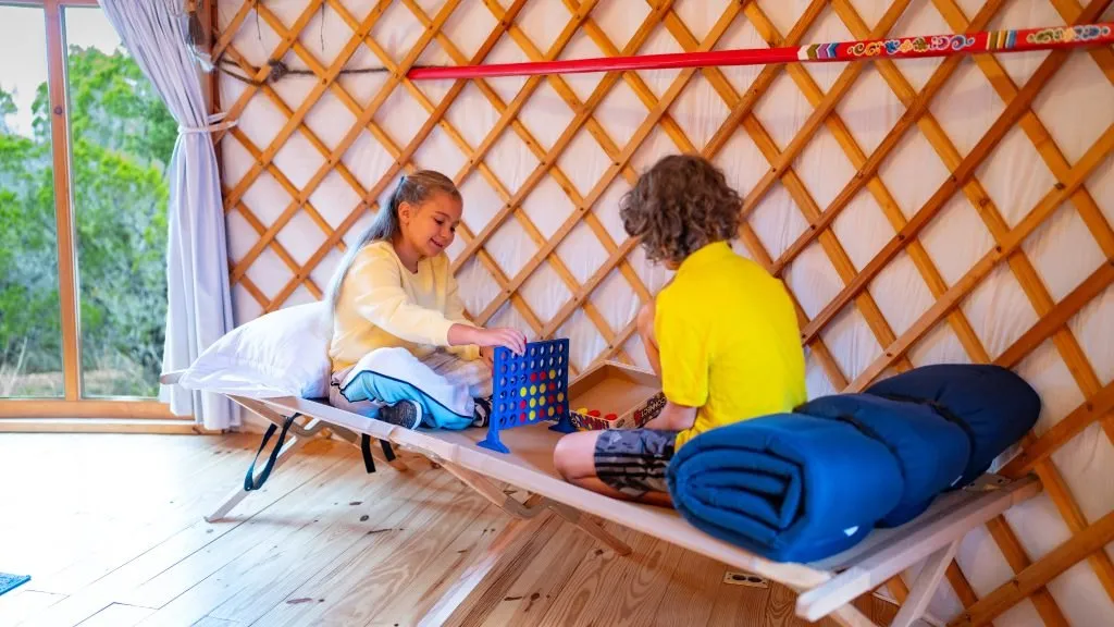 Children playing a card game inside a yurt at The Yurtopian